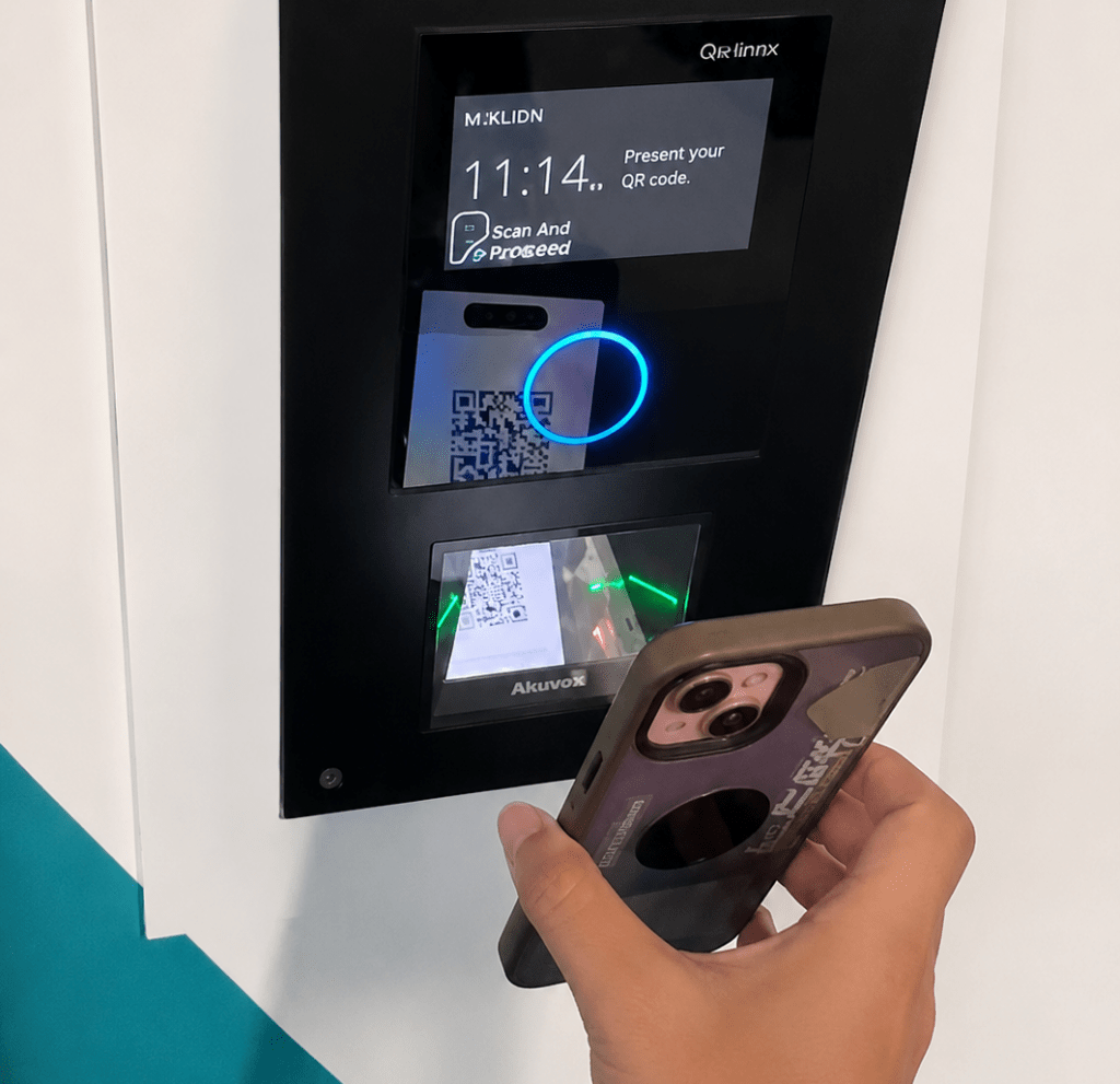 Member scanning a QR code on a smartphone at a gym access control reader for secure entry.
